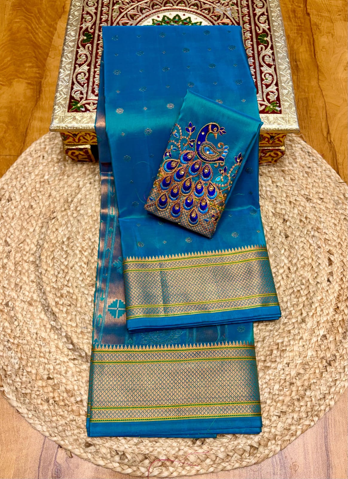 Elevate your festive and wedding wardrobe with the Trisha Kalanjali Paithani Saree, featuring elegant all-over butti weaving, a rich traditional pallu, and a beautifully detailed blouse with Aari work and Diamond Swarovski-style embellishments. Crafted from premium Tana soft silk for a graceful and comfortable drape