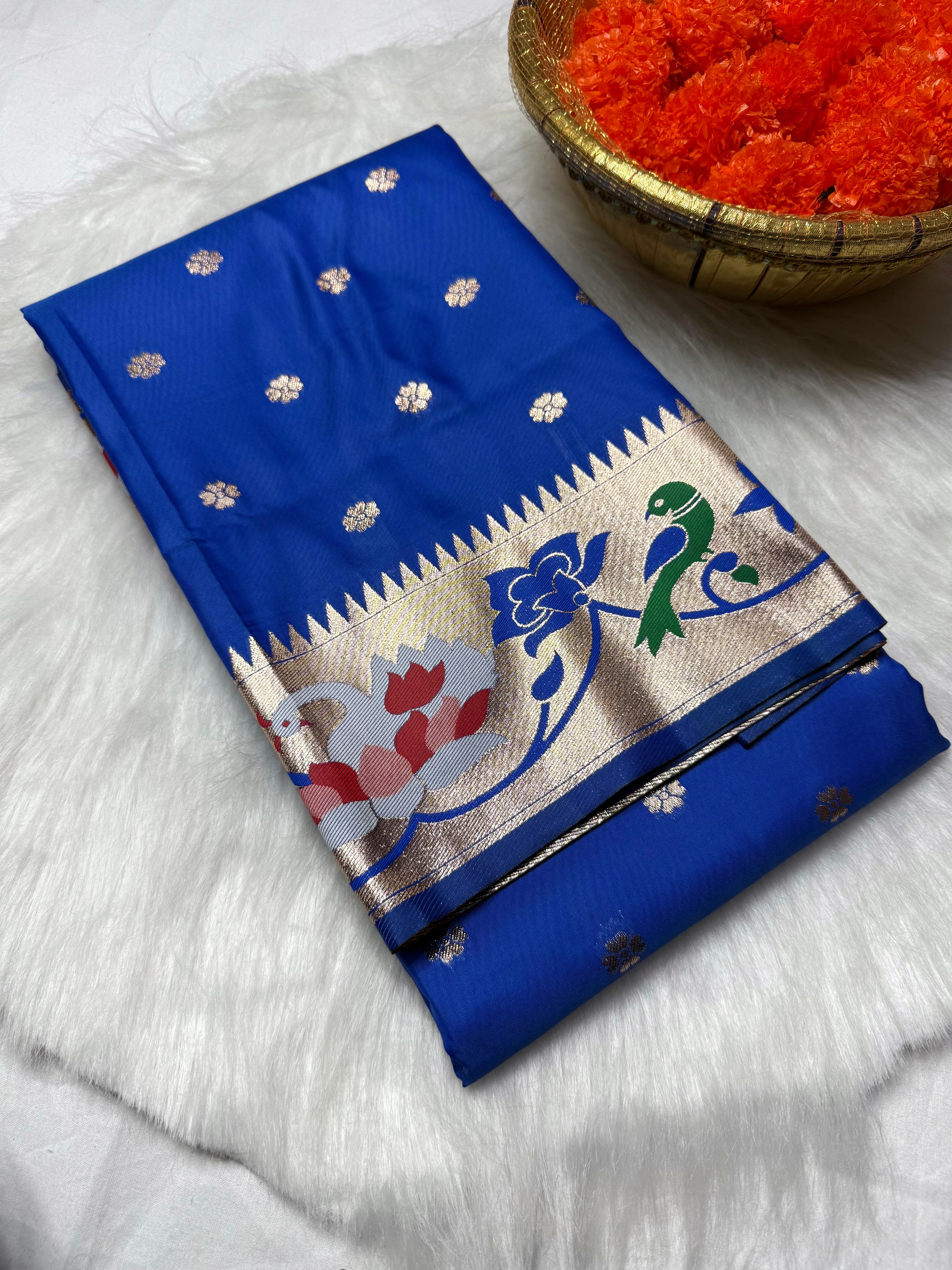 Experience timeless elegance with this Trending Rajhans Brocade Paithani Saree, crafted from premium pure soft silk. Designed with all-over traditional buttis and a luxurious 4/1 rich pallu, this saree reflects royal Maharashtrian craftsmanship. Comes with a matching running blouse piece, making it ideal for weddings, festive occasions, and traditional celebrations.