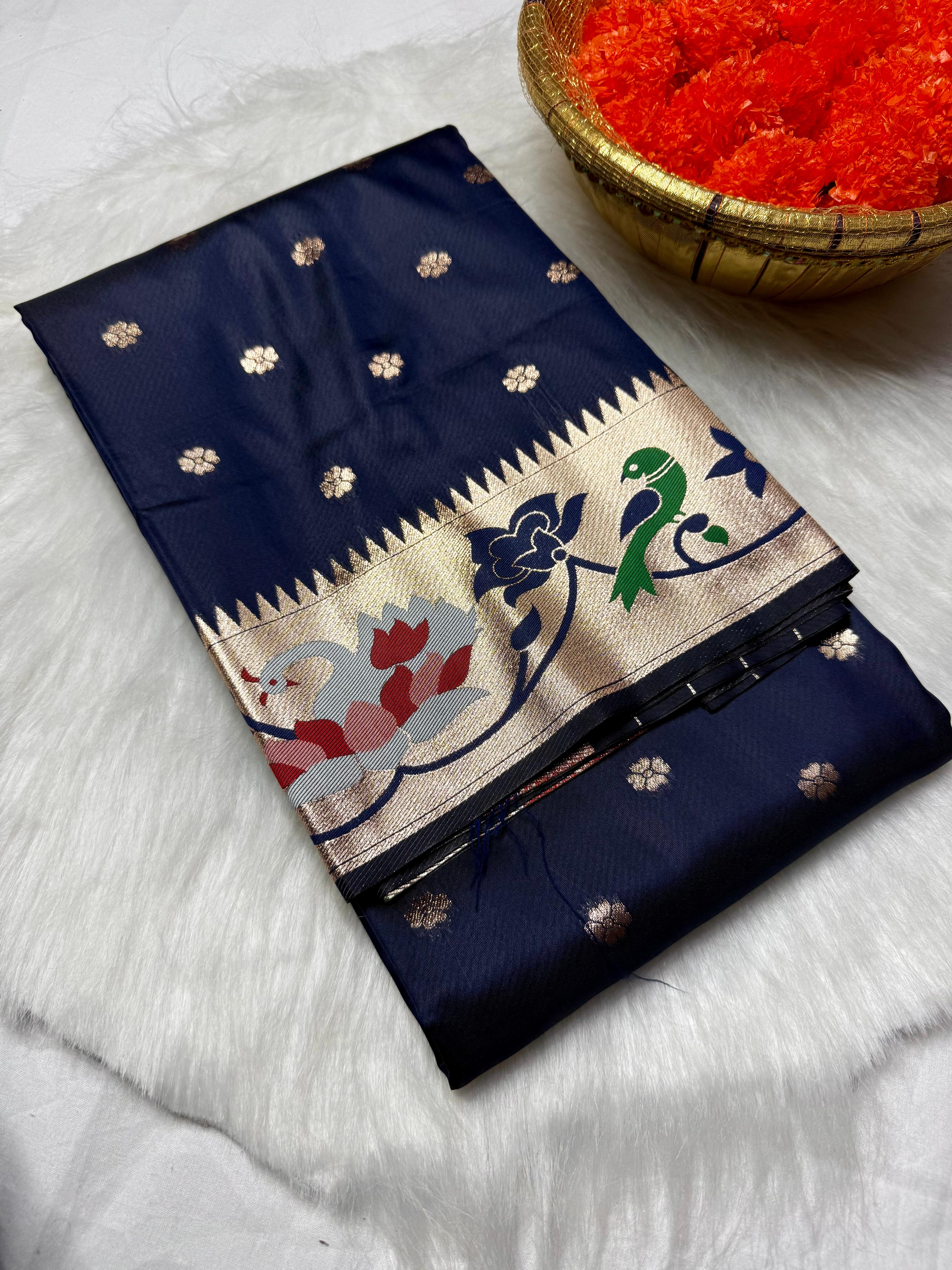 Experience timeless elegance with this Trending Rajhans Brocade Paithani Saree, crafted from premium pure soft silk. Designed with all-over traditional buttis and a luxurious 4/1 rich pallu, this saree reflects royal Maharashtrian craftsmanship. Comes with a matching running blouse piece, making it ideal for weddings, festive occasions, and traditional celebrations.