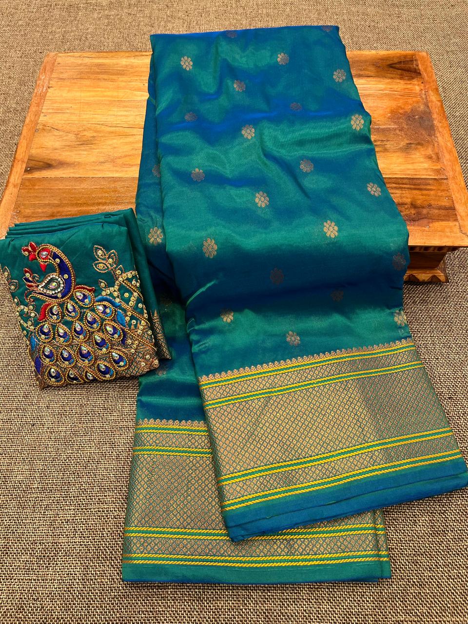 Grace your special occasions with this Traditional Border Kalanjali Paithani Saree, made from soft Tana silk and adorned with all-over buttis, a rich traditional border, and an elegant Aari Work Blouse Piece. Perfect blend of heritage and style for weddings and festive wear.