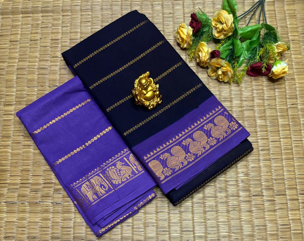 Navy blue and purple saree with gold patterns on a woven mat background