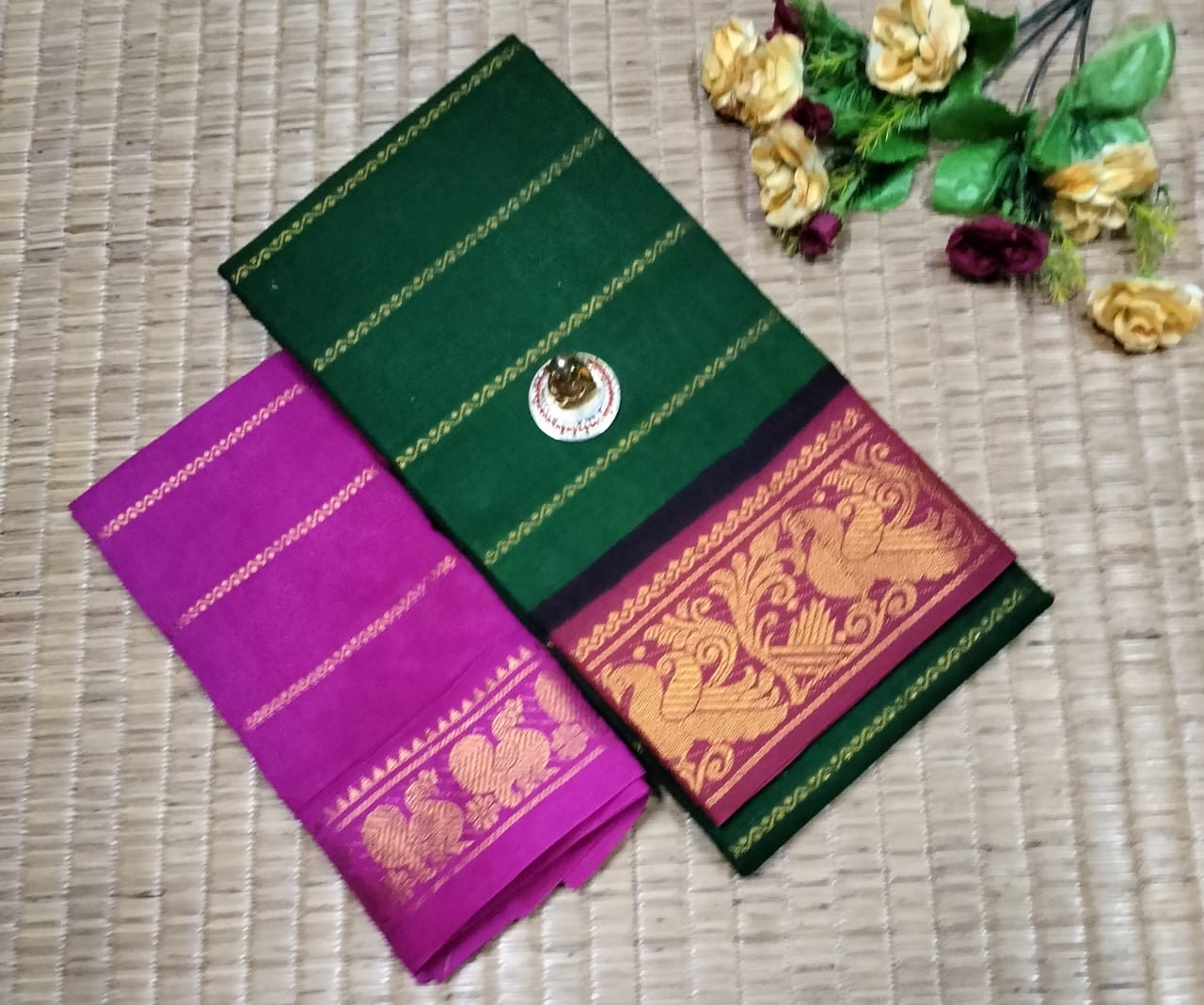 Green and purple saree with gold patterns on a woven surface