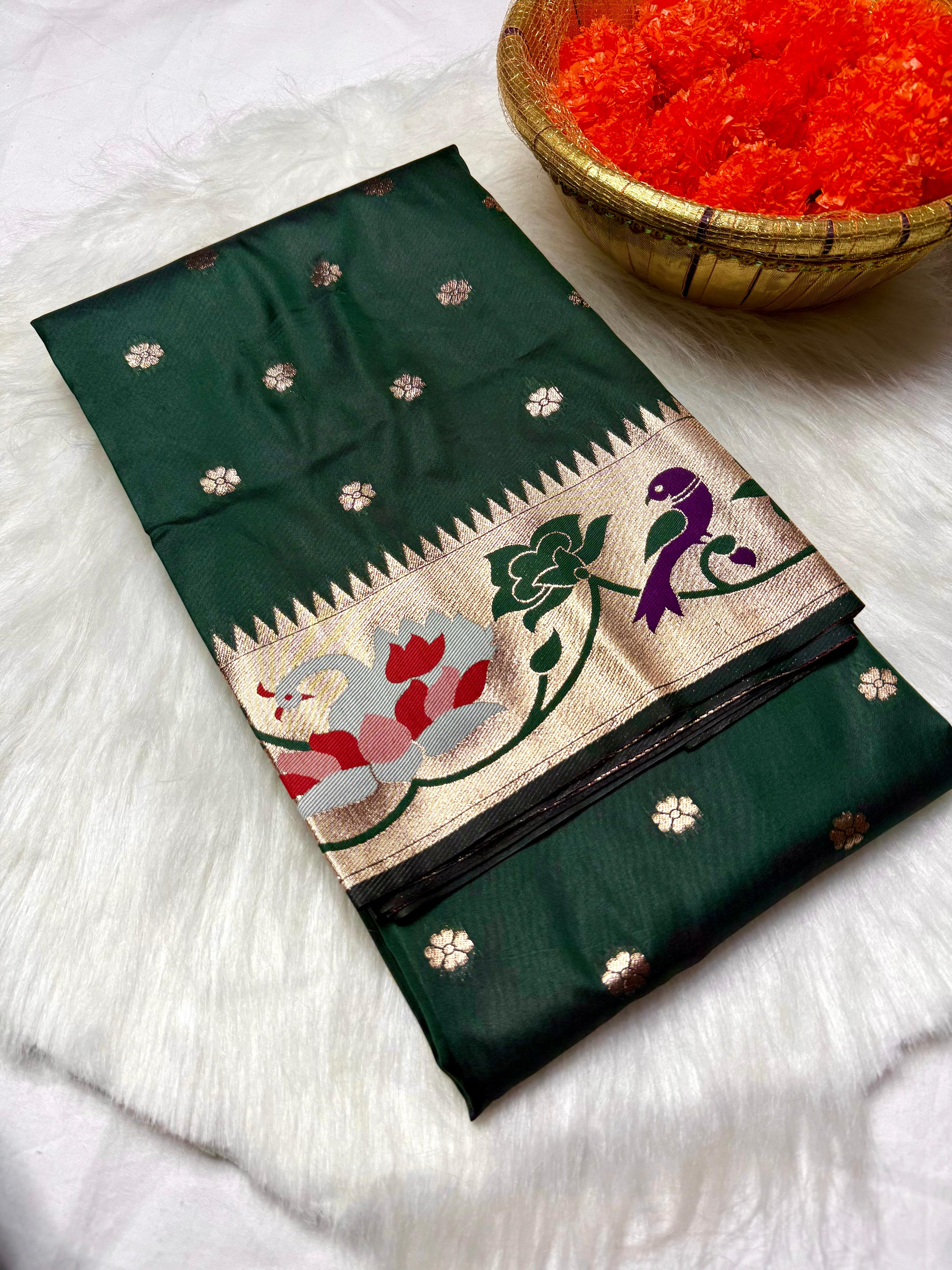 Experience timeless elegance with this Trending Rajhans Brocade Paithani Saree, crafted from premium pure soft silk. Designed with all-over traditional buttis and a luxurious 4/1 rich pallu, this saree reflects royal Maharashtrian craftsmanship. Comes with a matching running blouse piece, making it ideal for weddings, festive occasions, and traditional celebrations.