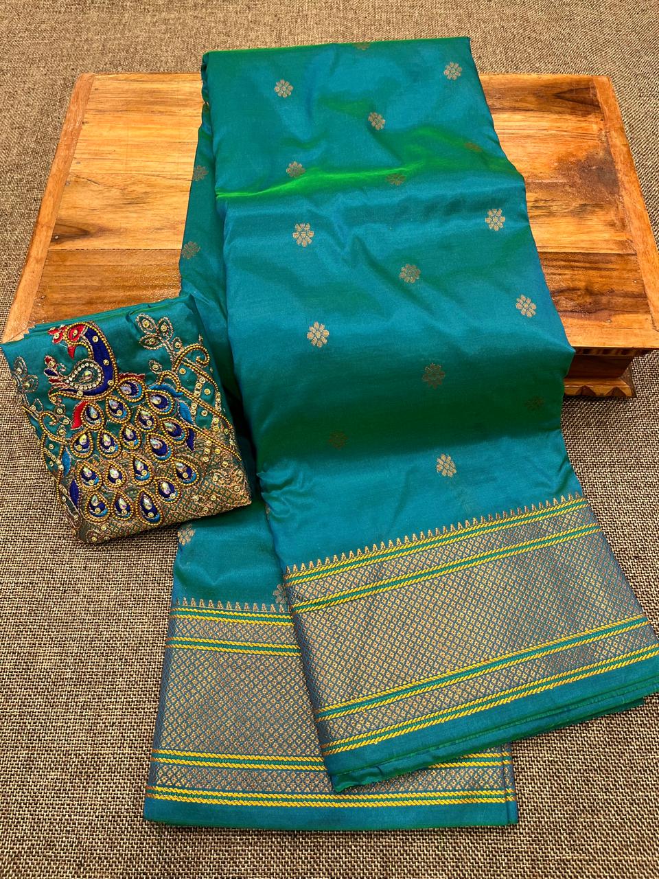 Grace your special occasions with this Traditional Border Kalanjali Paithani Saree, made from soft Tana silk and adorned with all-over buttis, a rich traditional border, and an elegant Aari Work Blouse Piece. Perfect blend of heritage and style for weddings and festive wear.