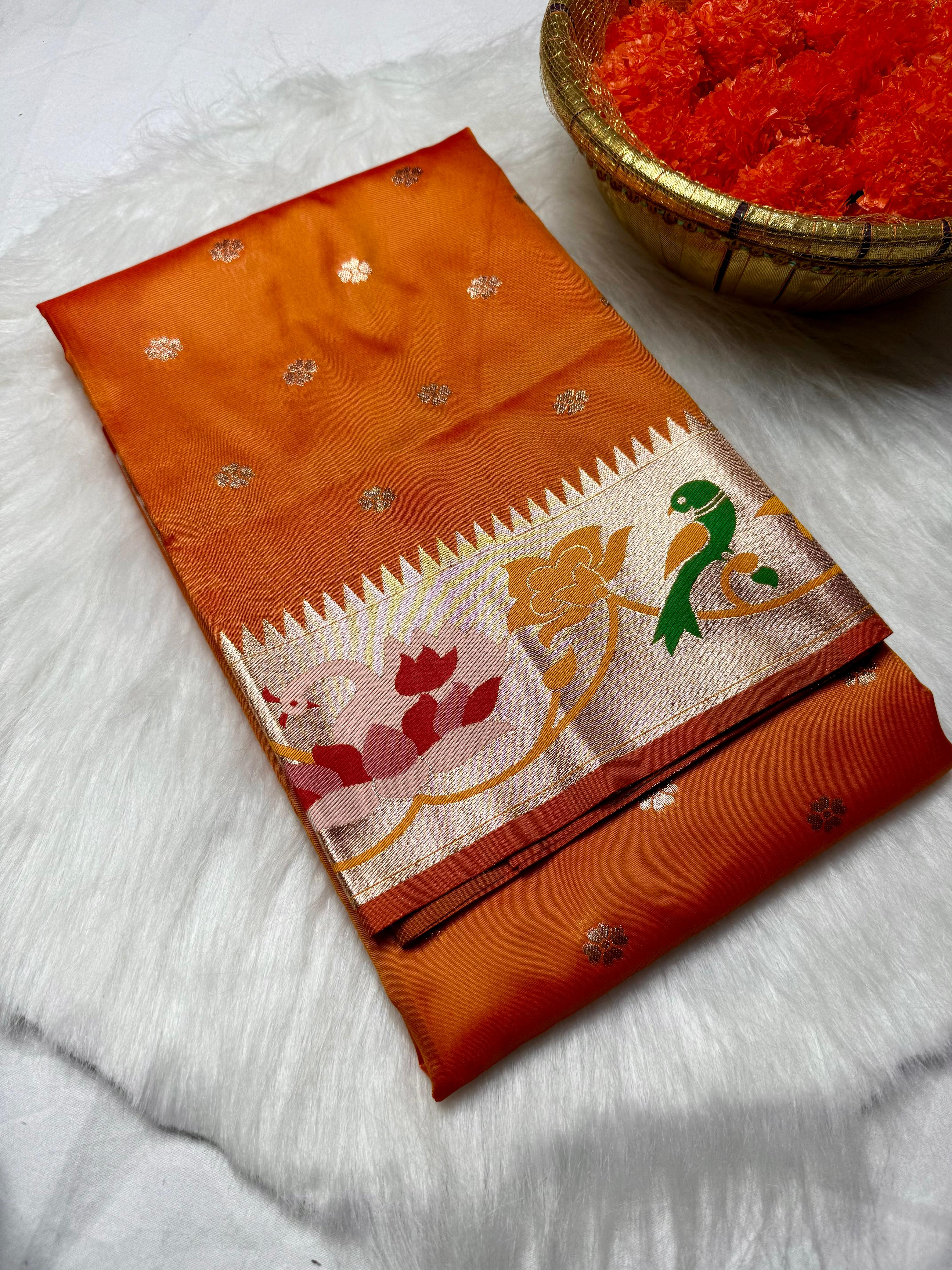 Experience timeless elegance with this Trending Rajhans Brocade Paithani Saree, crafted from premium pure soft silk. Designed with all-over traditional buttis and a luxurious 4/1 rich pallu, this saree reflects royal Maharashtrian craftsmanship. Comes with a matching running blouse piece, making it ideal for weddings, festive occasions, and traditional celebrations.