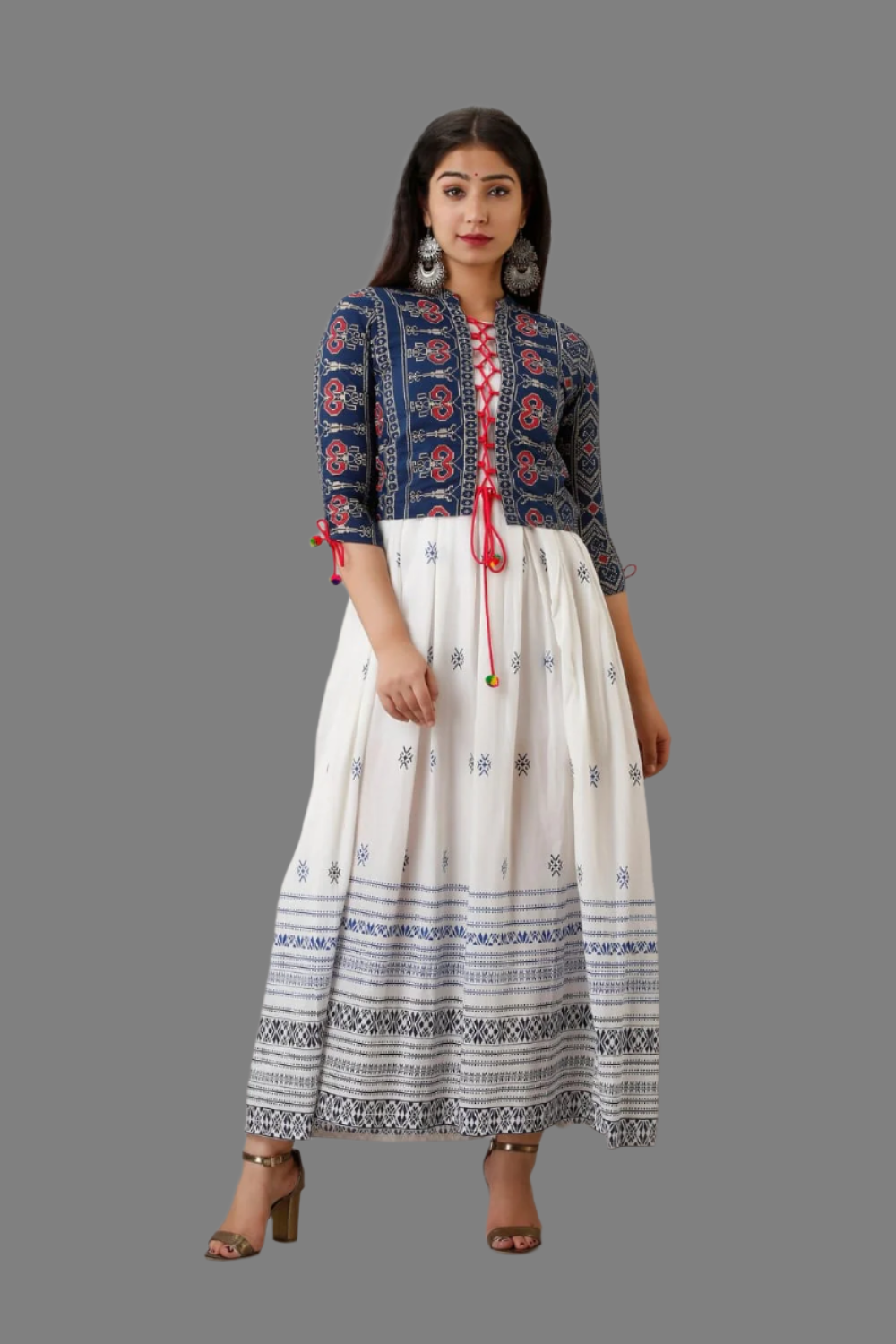 A woman wearing a traditional white long gown with a jacket, featuring geometric patterns and a red tie detail, posing against a frame with the text 'Pure Cotton'.