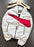 A white Nike windbreaker jacket with a bold red diagonal stripe across the chest, hanging on a wooden hanger against a dark gray background.