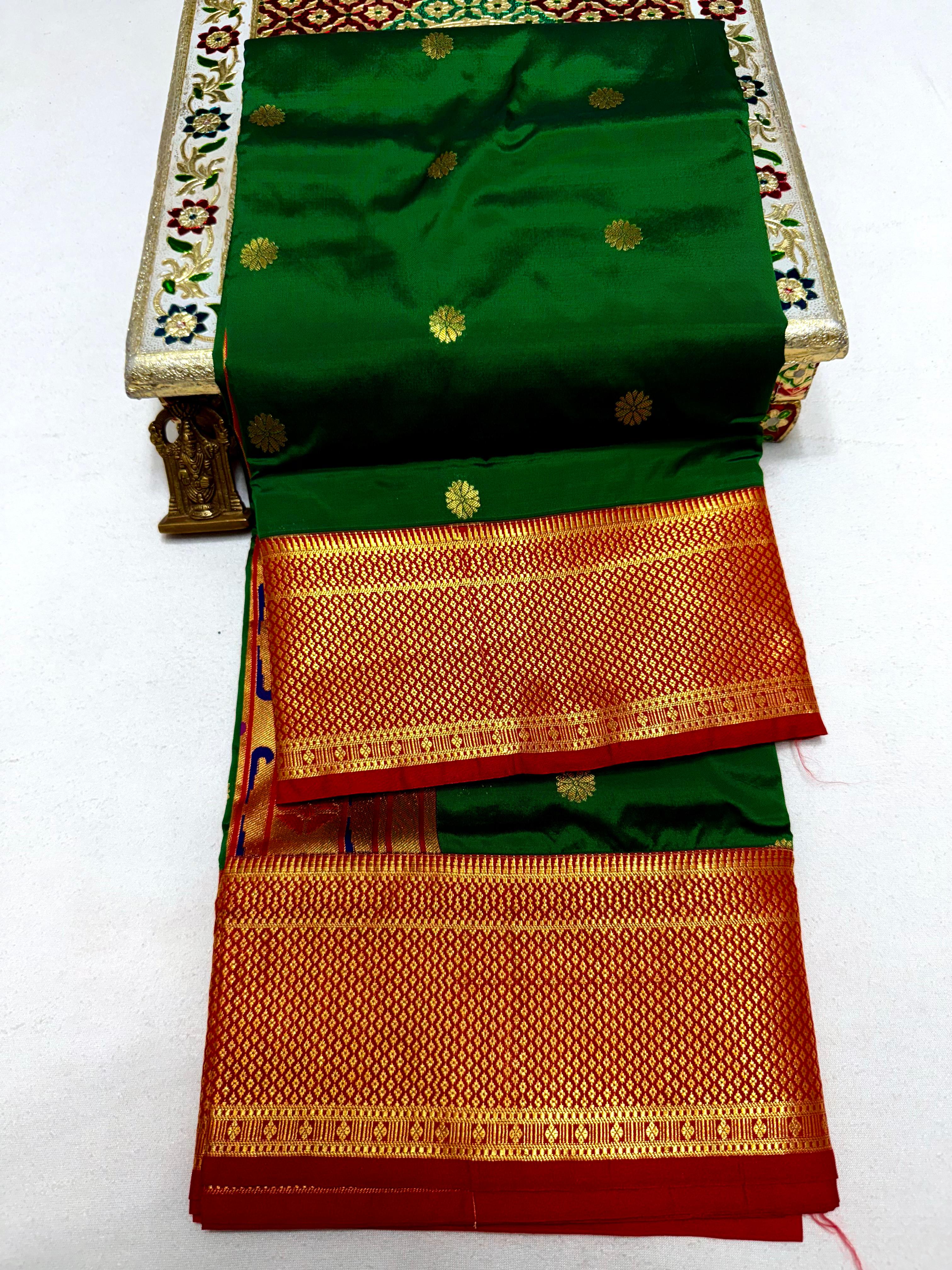 Green and red saree with gold patterns on a white background