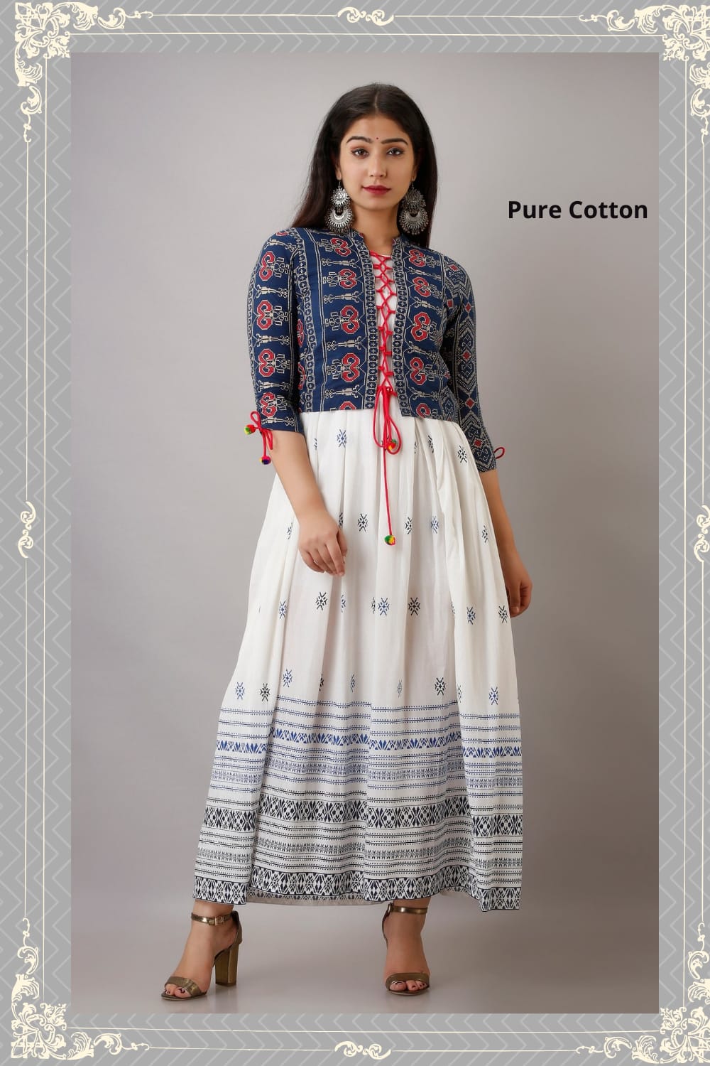 A woman wearing a traditional white long gown with a jacket, featuring geometric patterns and a red tie detail, posing against a frame with the text 'Pure Cotton'.